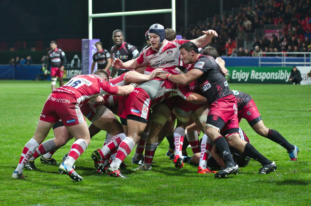 Rugby forwards packed into a maul during a match