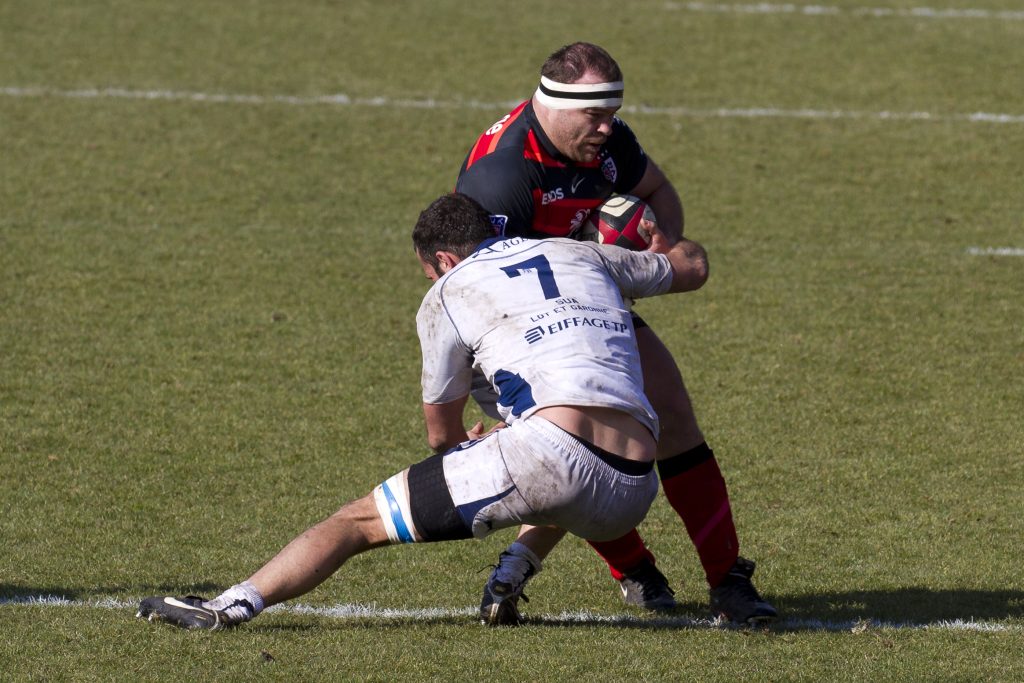 Rugby player making a tackle in open field play
